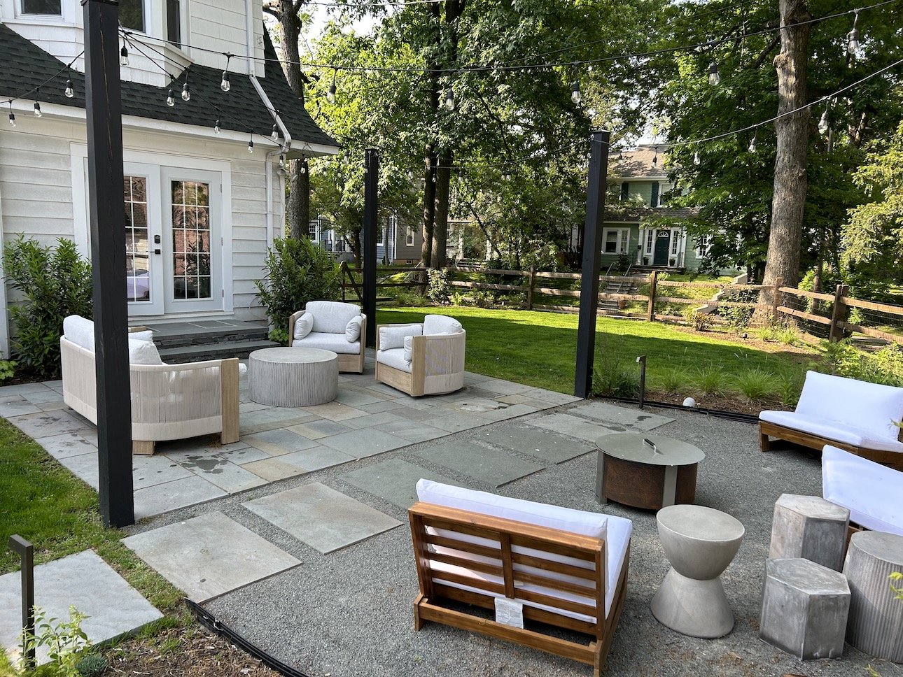 Luxury style patio with white furniture, stone walkways, greenery and italian string lights.jpg